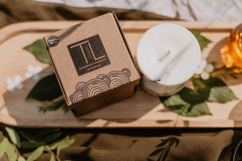 4. Flat lay of TL Candles soy wax candle and packaging on wooden tray with natural elements