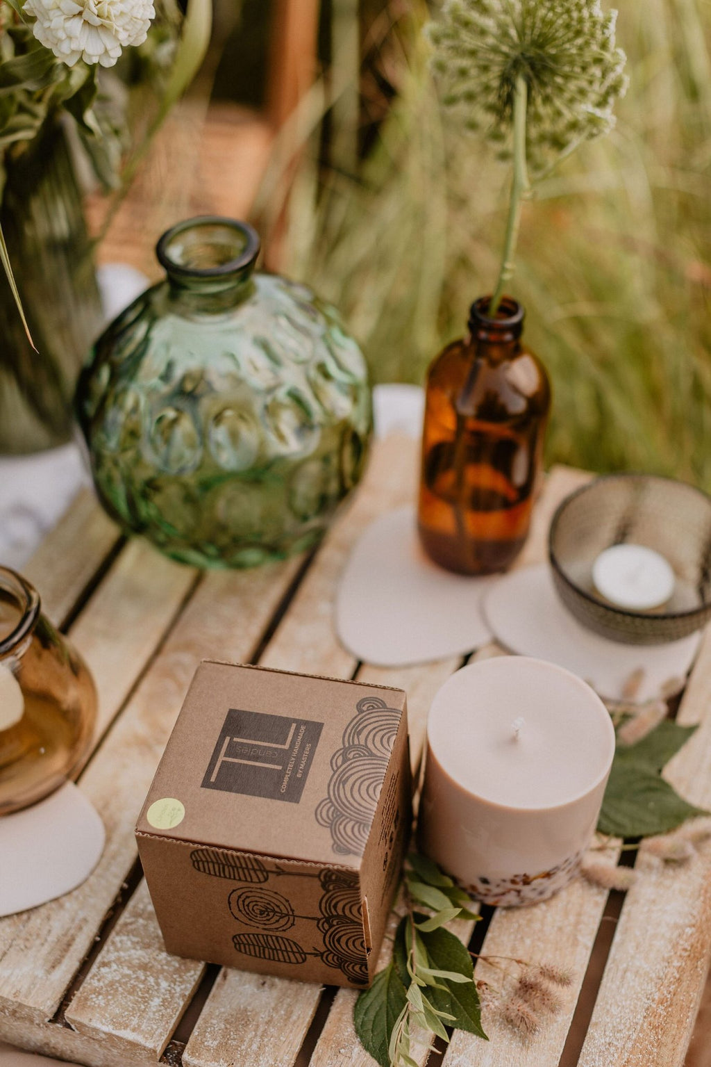 2. Woman holding TL Candles hand-made soy wax candle with amber pieces, showcasing its size and design