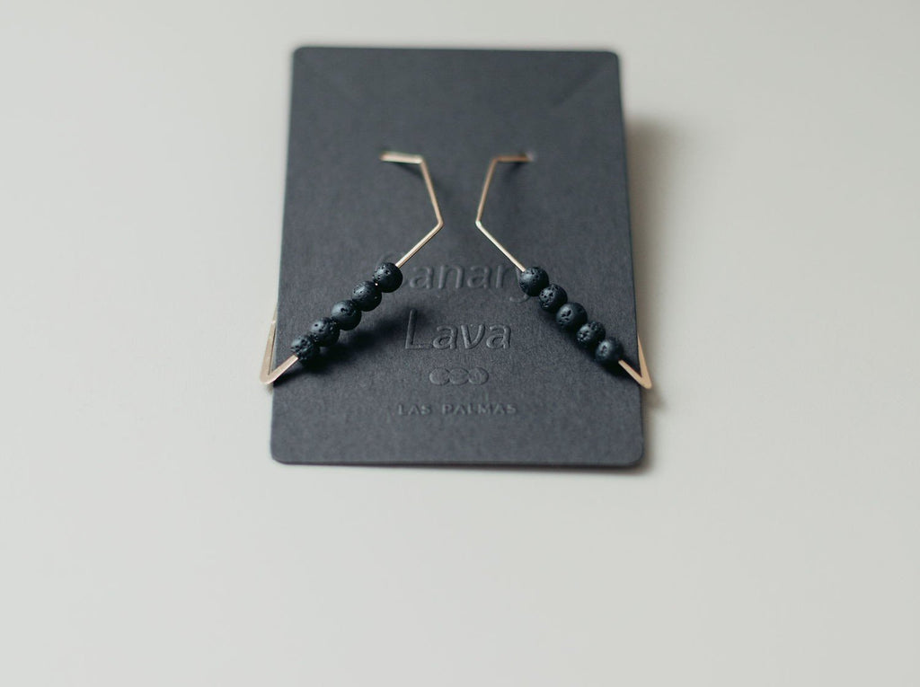 4. Close-up of Canary Lava 14K gold plated diffuser earrings with rhombus design on branded card