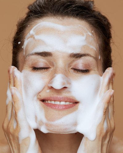 2. Woman applying Nurme Rose Face Cleansing Foam, showcasing gentle foaming action on skin