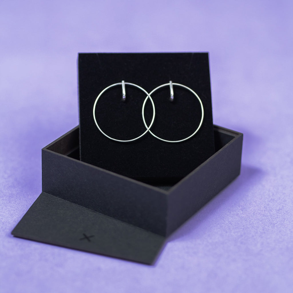 3. Maarja Palu LAYERS x2 silver earrings displayed in black box on purple background, emphasizing minimalist style