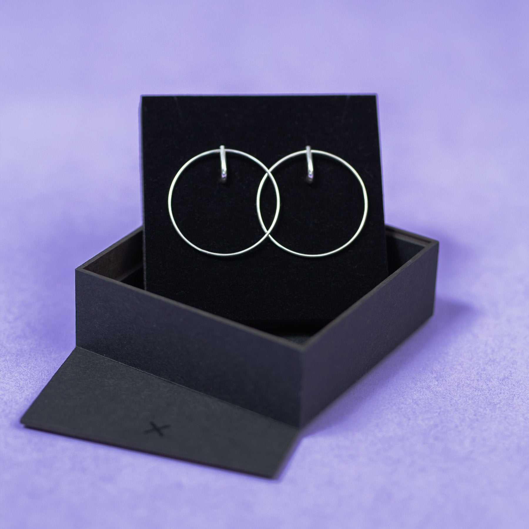3. Maarja Palu LAYERS x2 silver earrings displayed in black box on purple background, emphasizing minimalist style