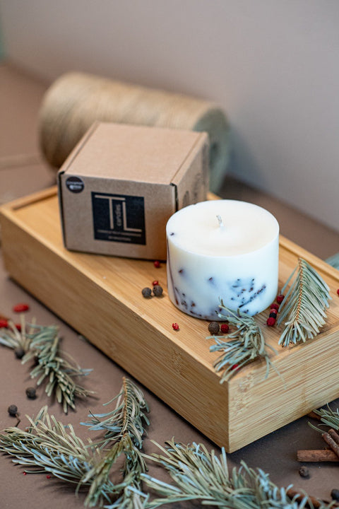 5. TL Candles soy wax candle with cinnamon and clove, shown with packaging on wooden tray