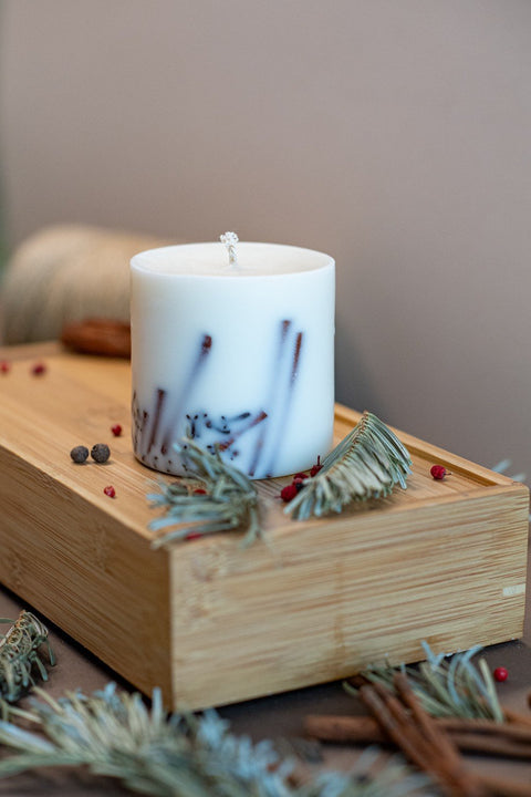 2. Close-up of TL Candles soy wax candle with cinnamon and clove decoration on wooden tray