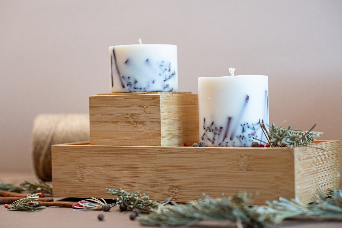 1. Hand-made soy wax candles with cinnamon sticks and cloves on wooden tray, creating a cozy atmosphere
