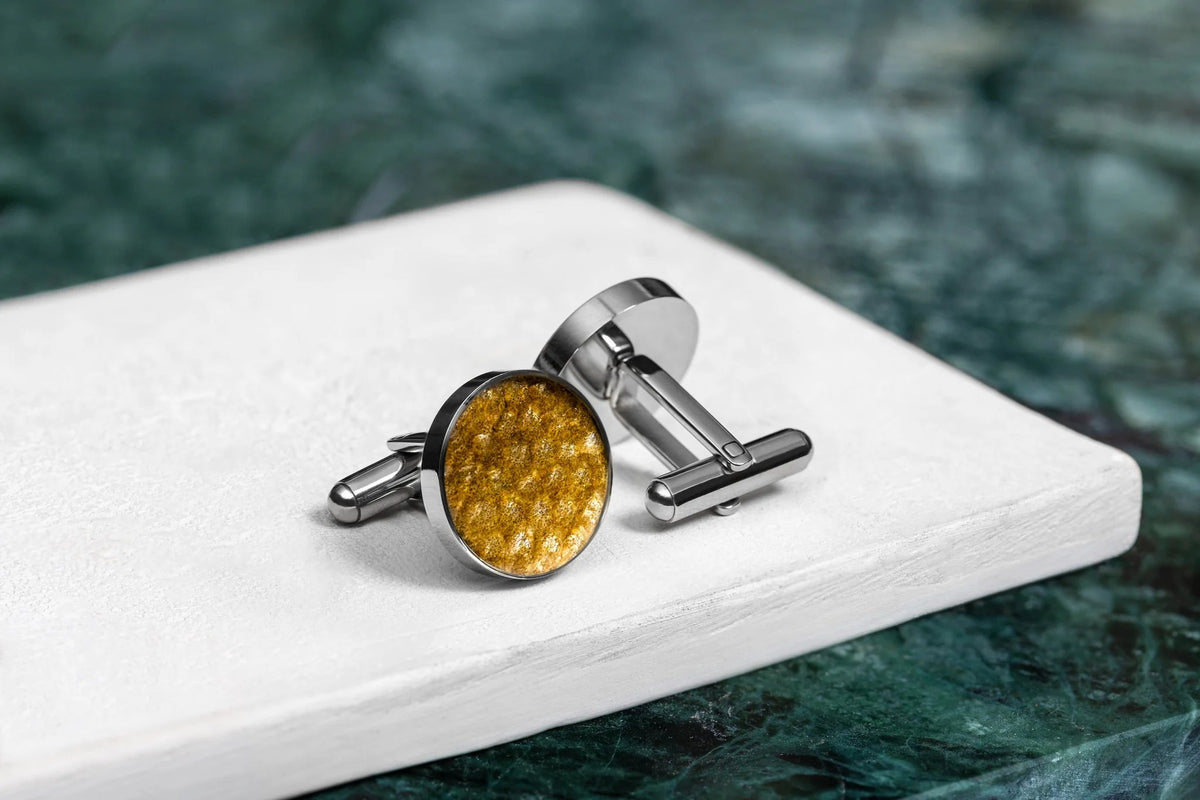 3. Pair of Eherüs round cufflinks with yellow trout leather on white surface