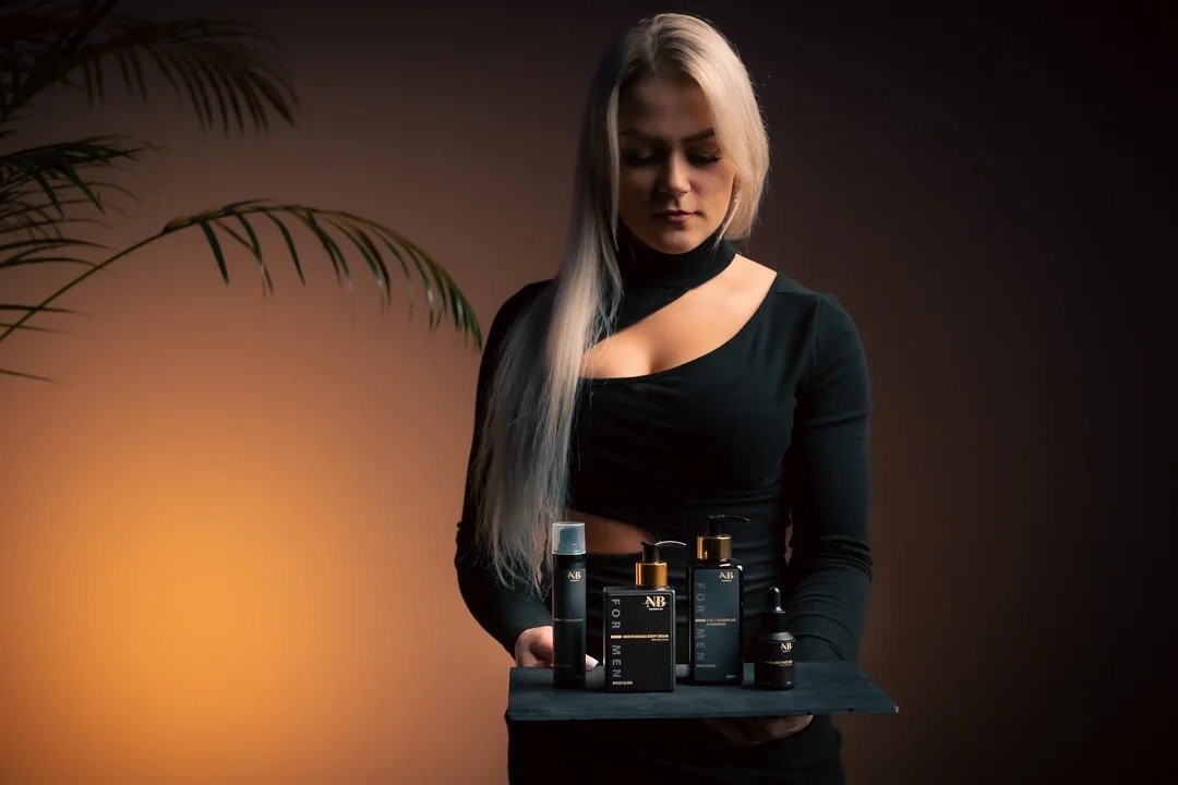1. Woman holding a tray with North Beauty men's skincare products, including moisturising hand cream with aloe vera, in a lifestyle setting