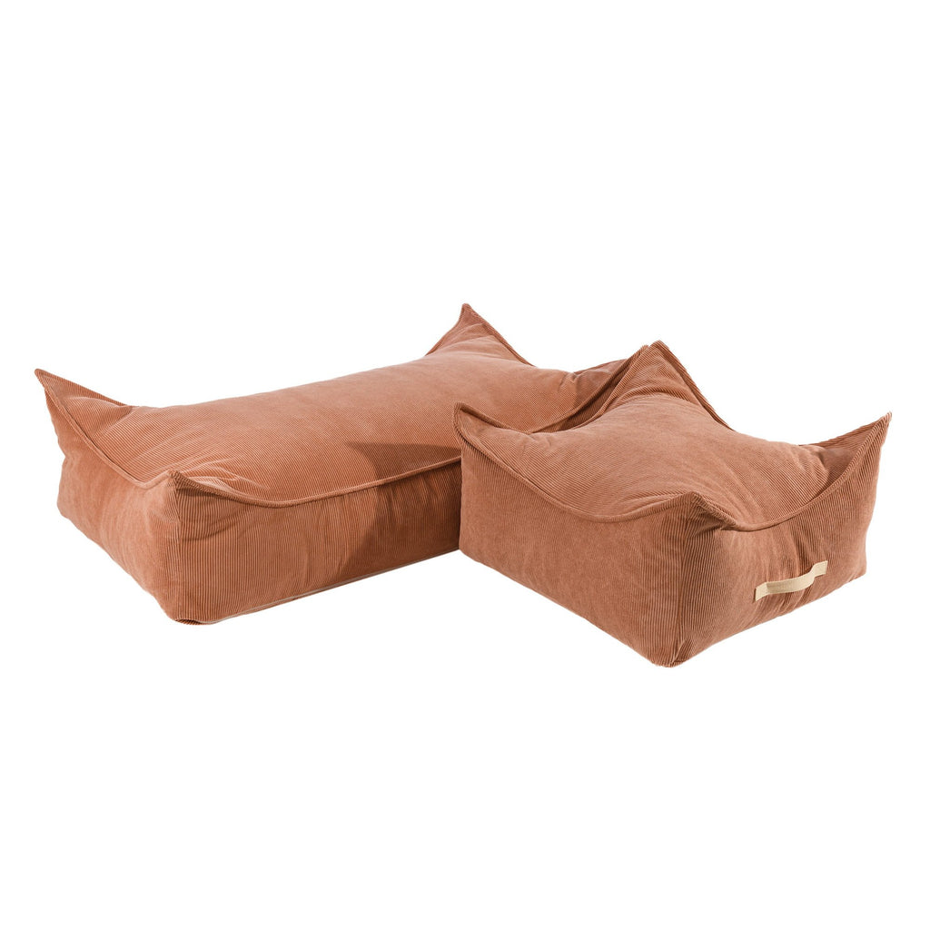 3. Two brick-colored corduroy poufs for children, one square and one rectangular, displayed together in a studio setting