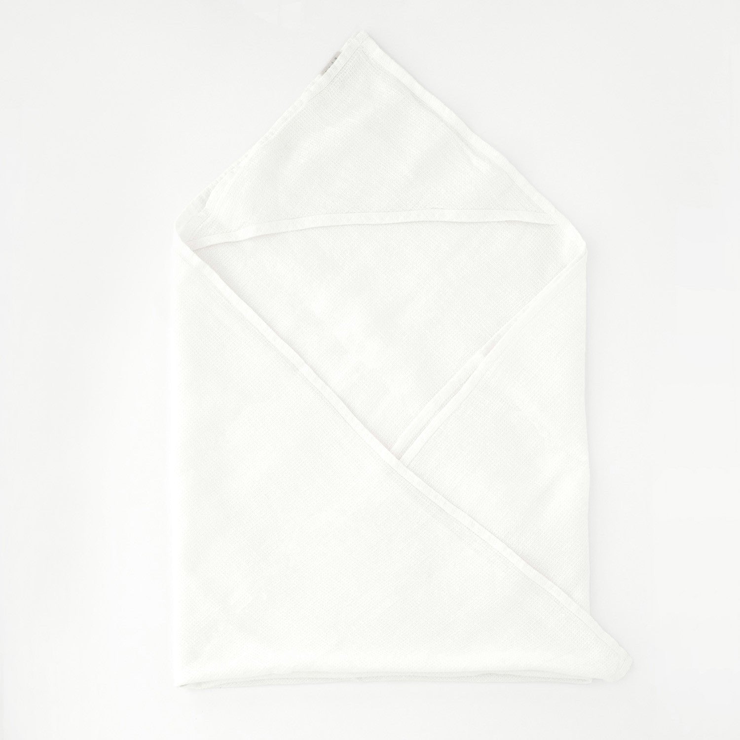 2. White linen hooded waffle towel for kids laid flat on a clean white background