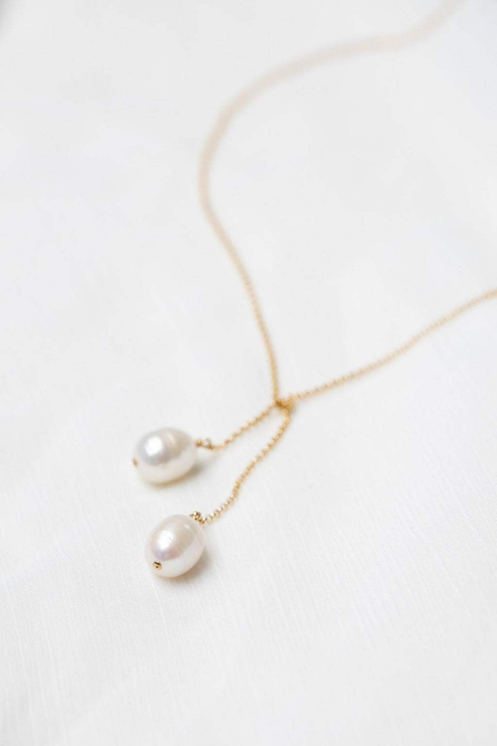 3. Close-up of TIED TO COCO - Pearl necklace by New Vintage by Kriss, highlighting two large pearls on a delicate gold-filled chain