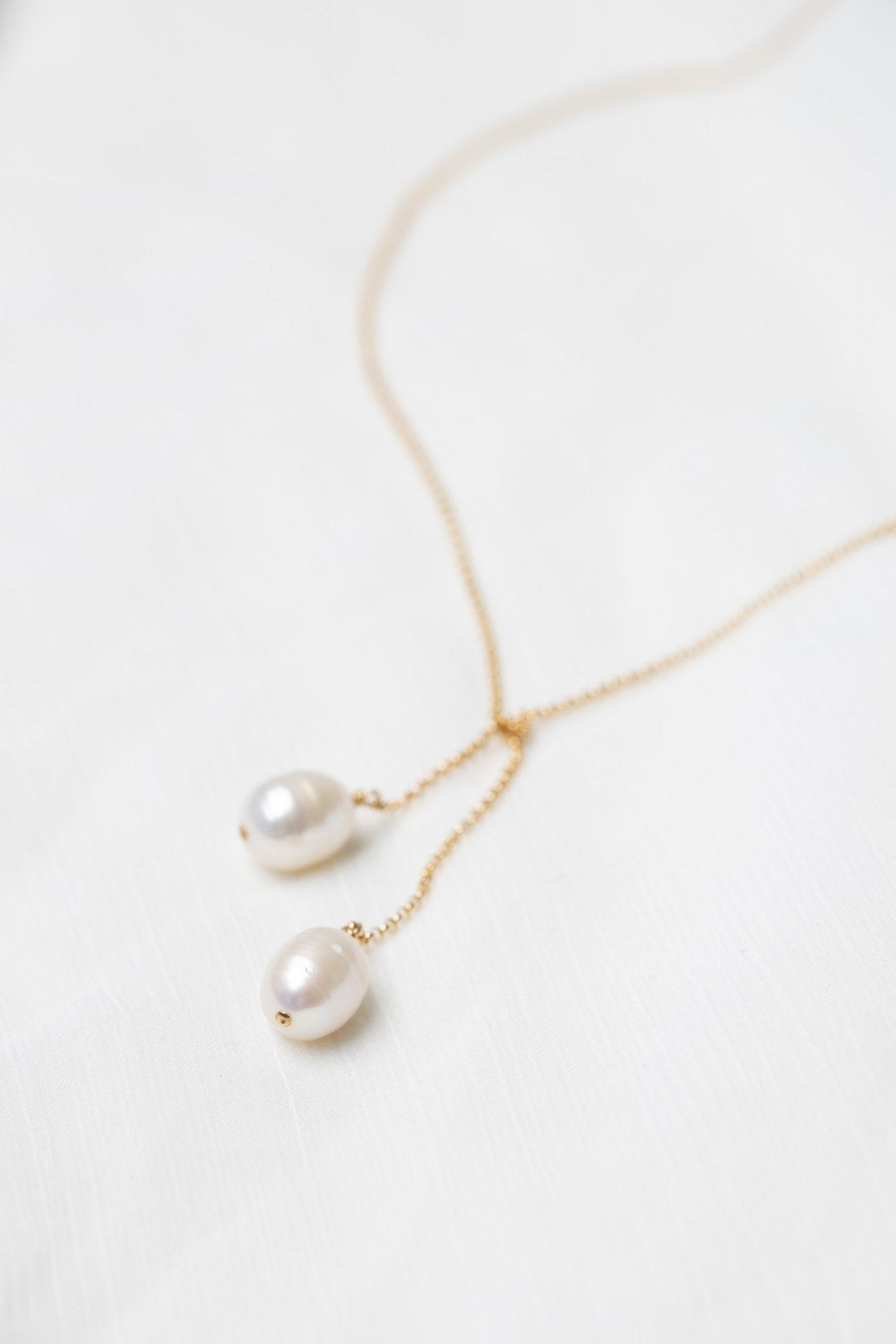 3. Close-up of TIED TO COCO - Pearl necklace by New Vintage by Kriss, highlighting two large pearls on a delicate gold-filled chain