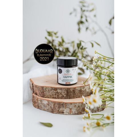 1. MaiWistik HAPPIK Rejuvenating Face Balm 30ml displayed on wooden slices with flowers, showcasing natural ingredients and award recognition