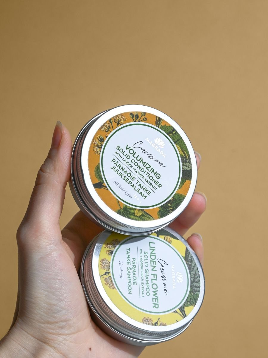 4. Hand holding Magrada Volumizing Solid Conditioner and Linden Flower Shampoo, emphasizing eco-friendly design