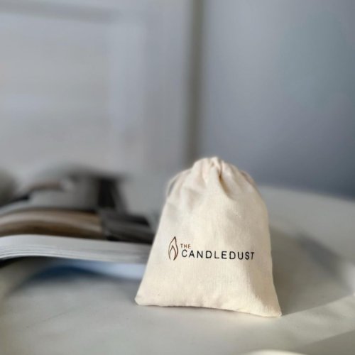 7. Candledust branded drawstring bag on a table, perfect for storing candle accessories