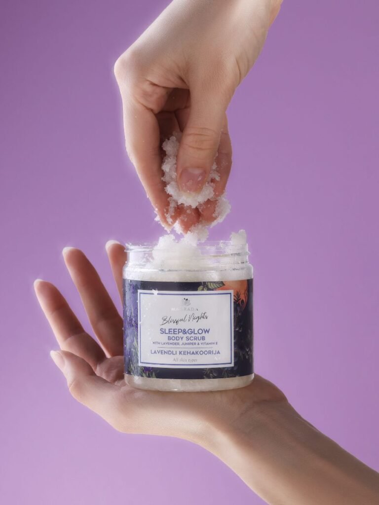 1. Woman applying Magrada Organic Cosmetics Lavender Body Scrub with Grapefruit Essential Oil, showcasing texture and packaging