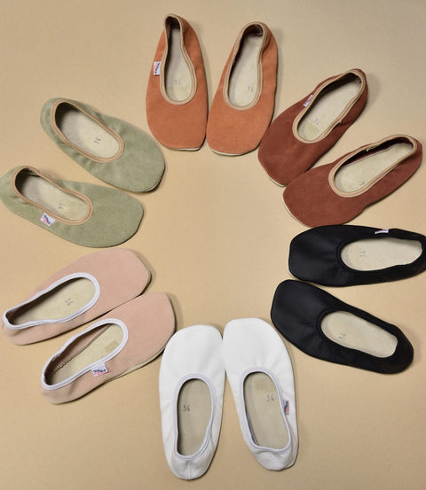 5. Flat lay of various colored barefoot slippers by Hip-Hop, including black, white, and pastel shades