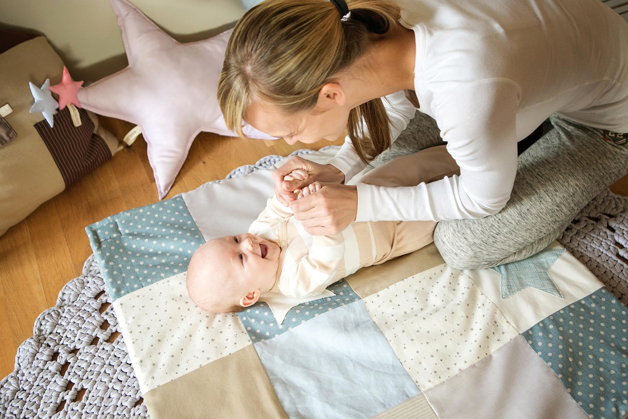 2. Baby and adult interacting on Karloova activity mat with star toys
