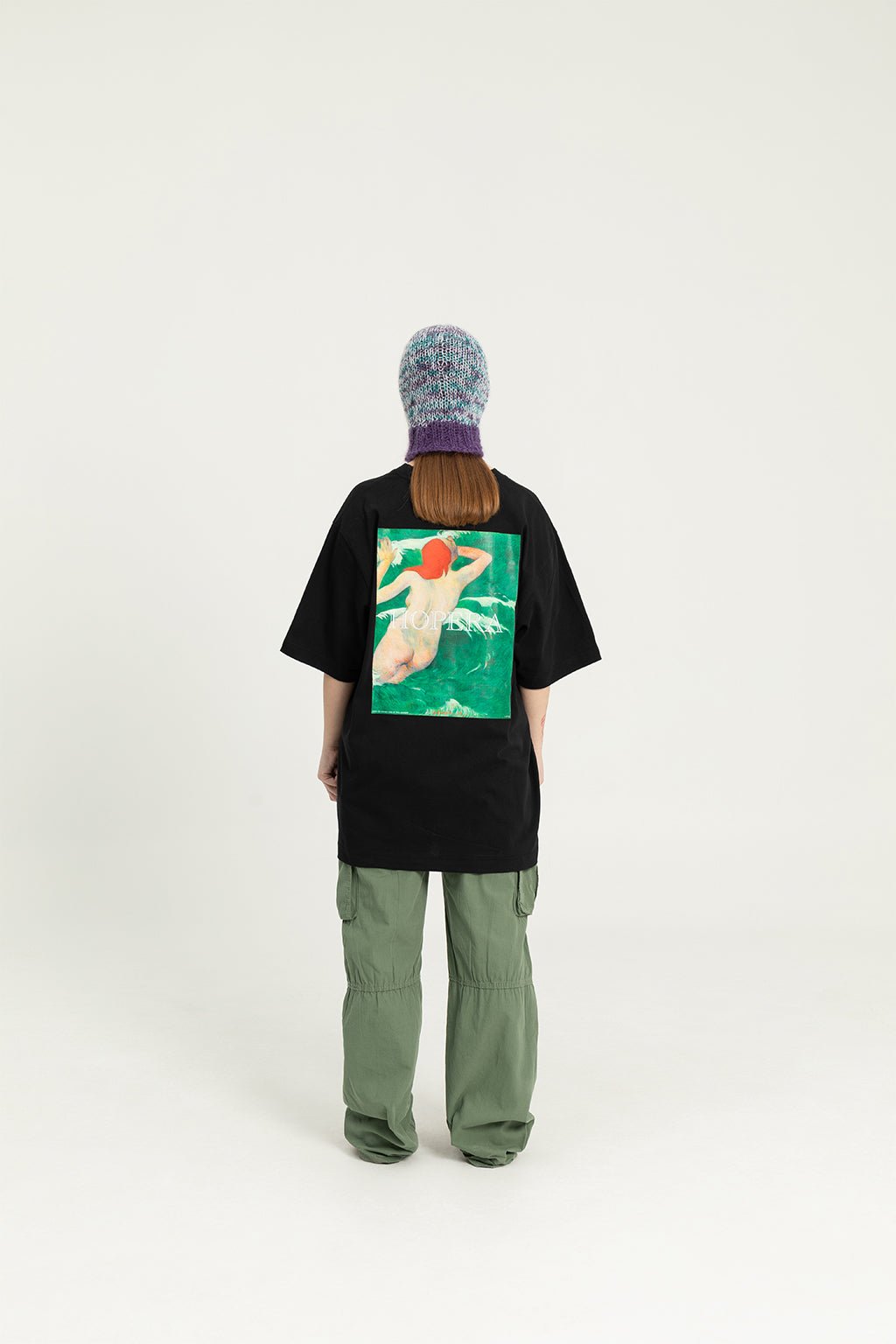 4. Black Hopera T-shirt with 'Dans les Vagues' design, worn by female model in studio, back view