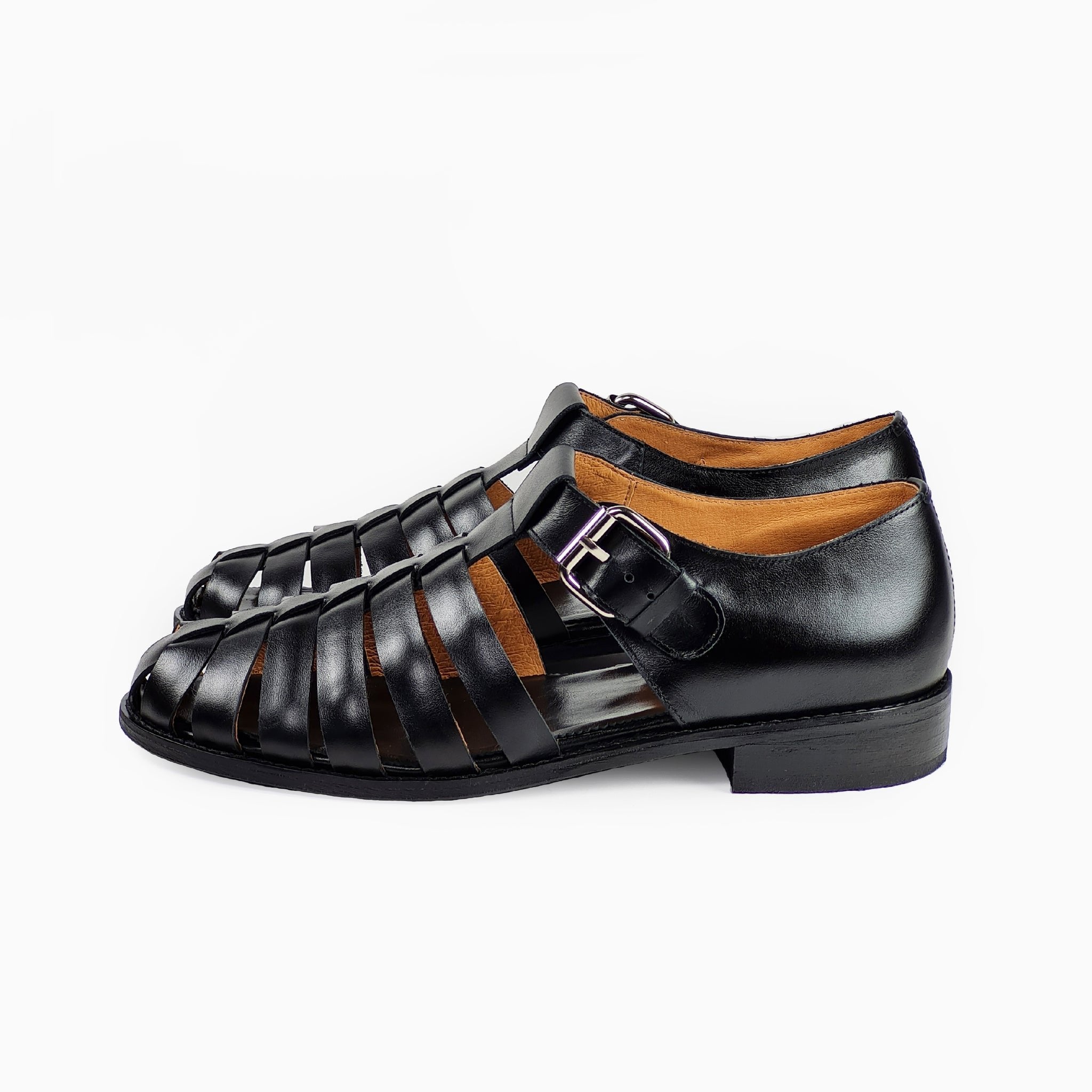 5. Profile view of men's black leather fisherman sandals with adjustable buckle, studio setting