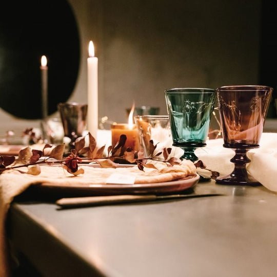 6. Elegant table setting with La Rochère Bee Glasses in blue and purple, surrounded by candles and decorative foliage
