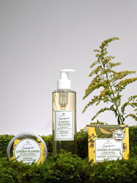 3. Magrada Organic Cosmetics Linden Flower hair care set including shampoo, solid shampoo, and conditioner on moss with floral background