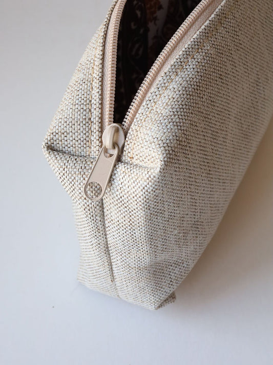 2. Side view of TOKS VISOKS LORNA Makeup Bag in White Sand, highlighting smooth zipper and textured fabric