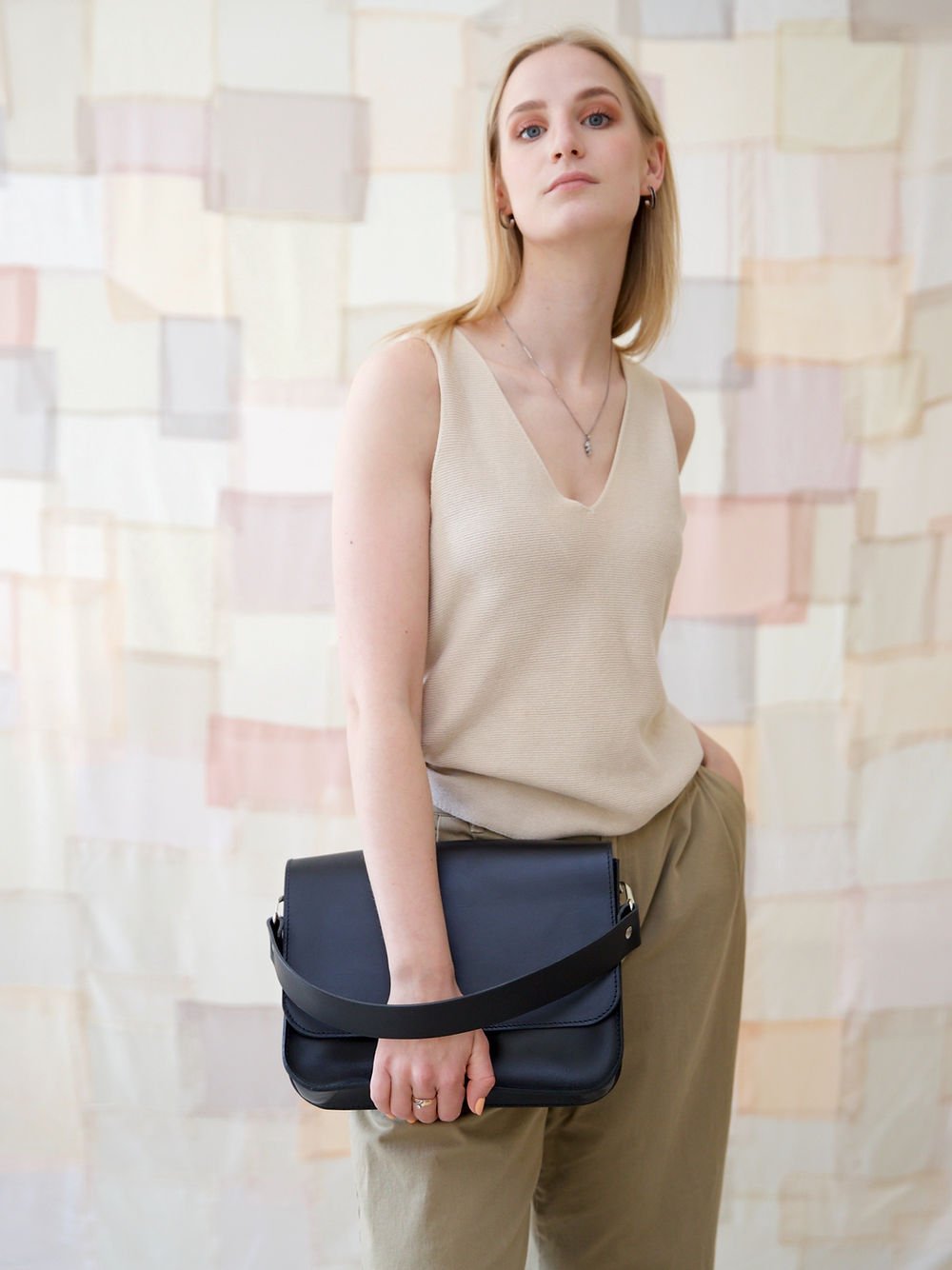 4. Woman carrying TOKS VISOKS ASTORIA black handbag, highlighting spacious design and style