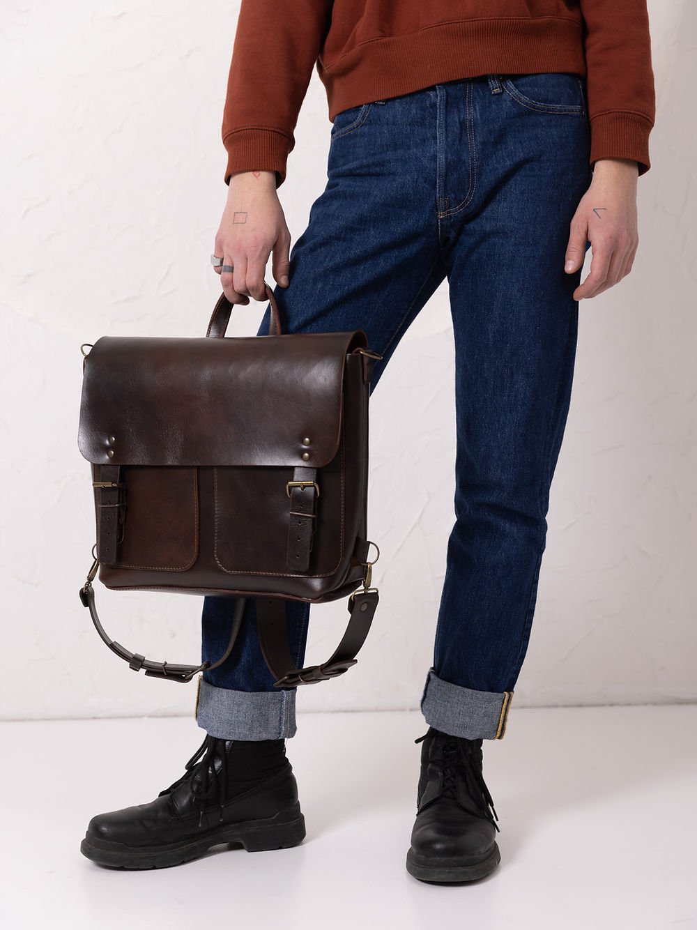 1. Male and female models showcasing TOKS VISOKS BENJAMIN Backpack in dark chocolate leather, styled for urban commuting