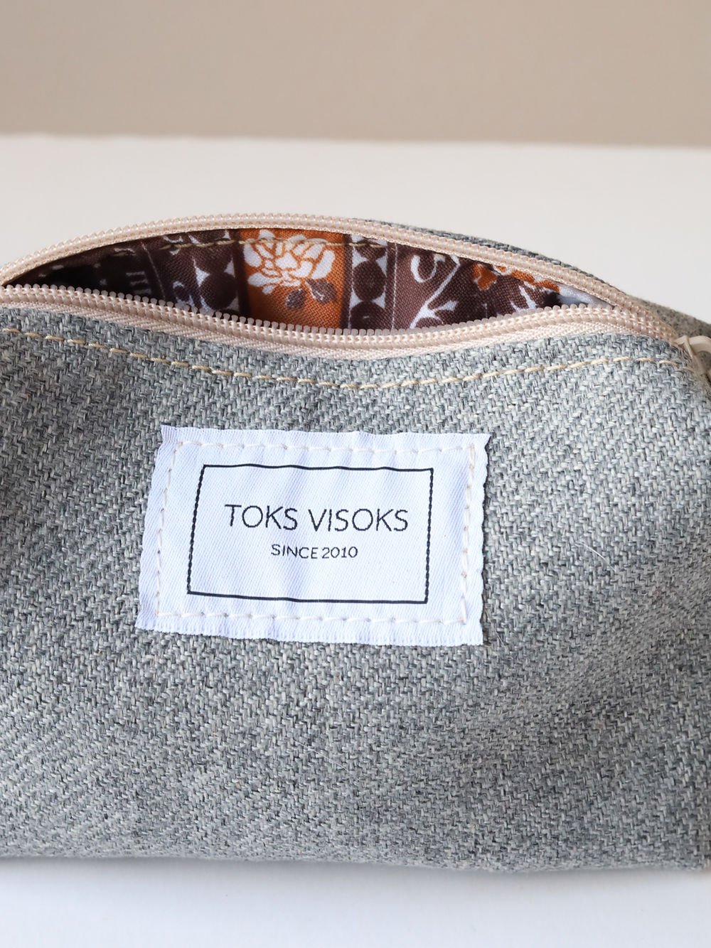 1. Close-up of TOKS VISOKS LORNA grey makeup bag showing interior lining and brand label
