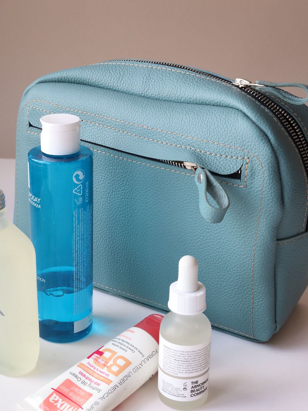 1. TOKS VISOKS DOUGLAS turquoise toiletry bag with beauty products, showcasing spacious design and front zipped pocket