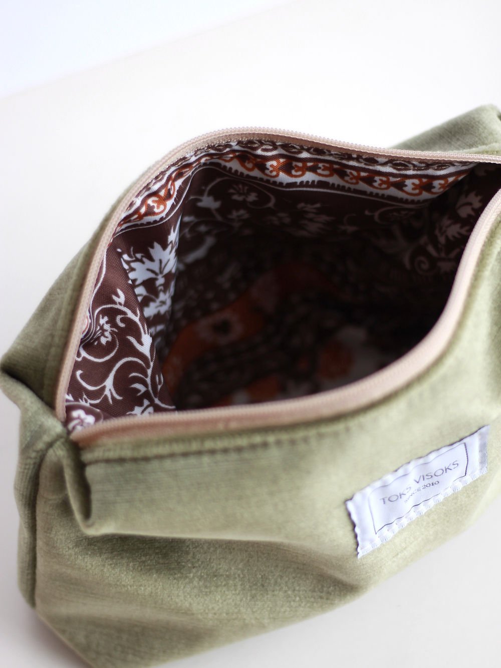 4. Inside view of LORNA Makeup Bag in olive velvet, highlighting patterned lining and open zipper
