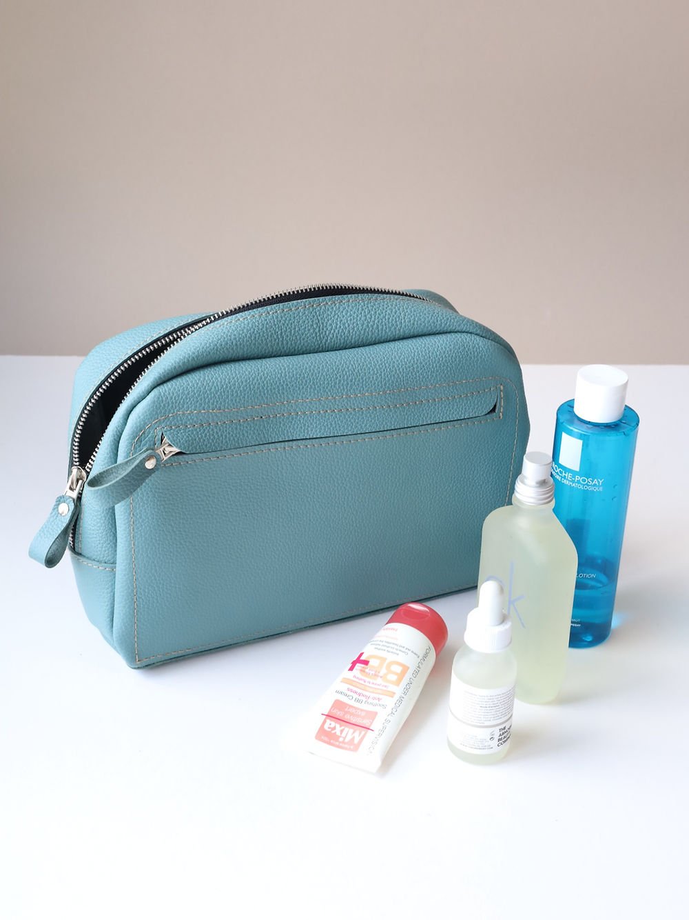 3. TOKS VISOKS DOUGLAS turquoise toiletry bag with beauty essentials, emphasizing eco-friendly handmade leather