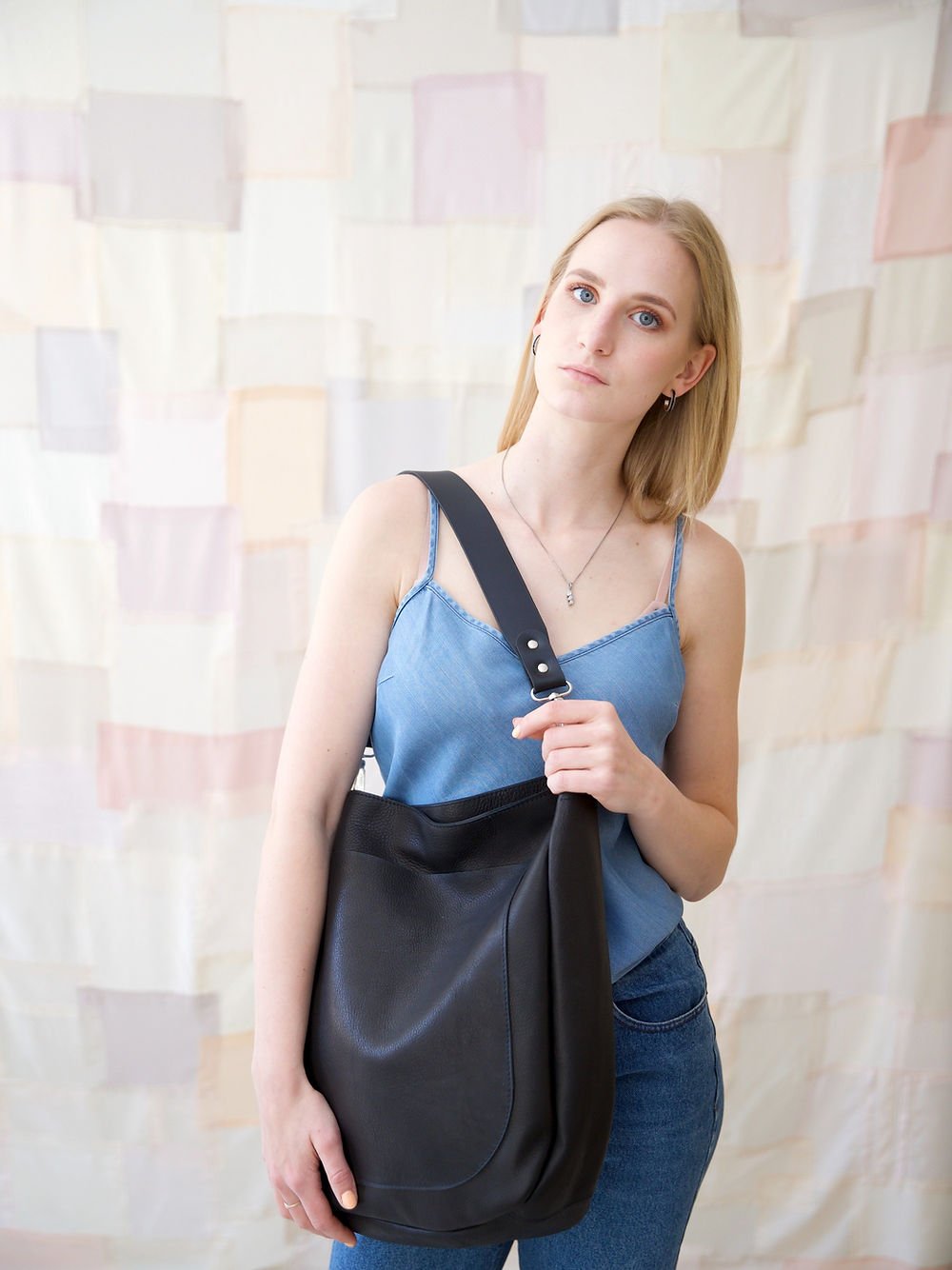 5. Woman holding LULU black handbag by TOKS VISOKS, emphasizing elegant design
