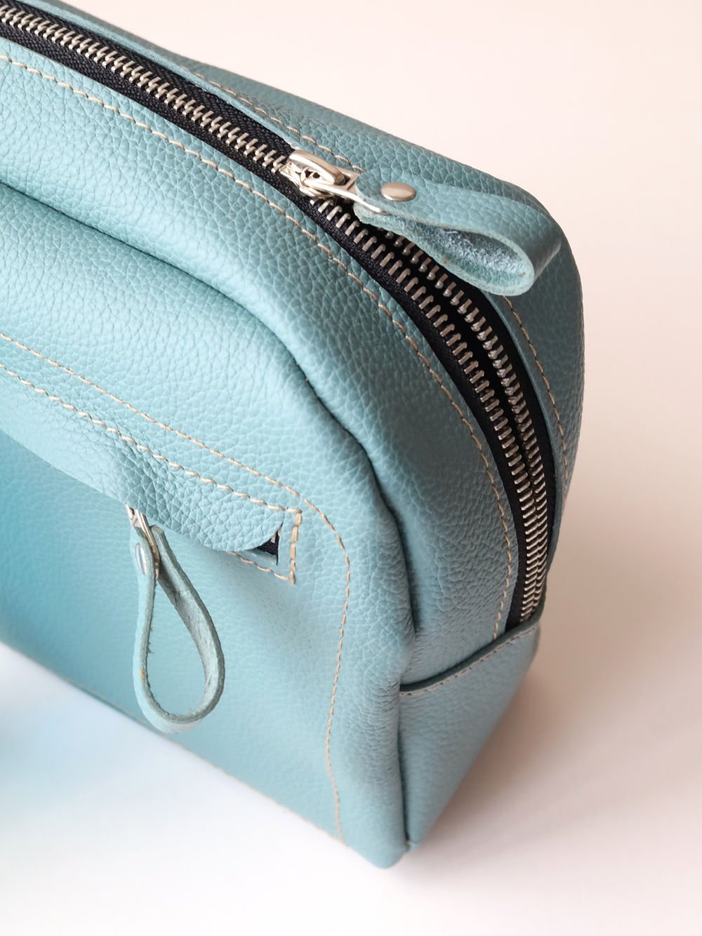 2. Close-up of TOKS VISOKS DOUGLAS turquoise toiletry bag highlighting smooth zipper and handmade leather texture