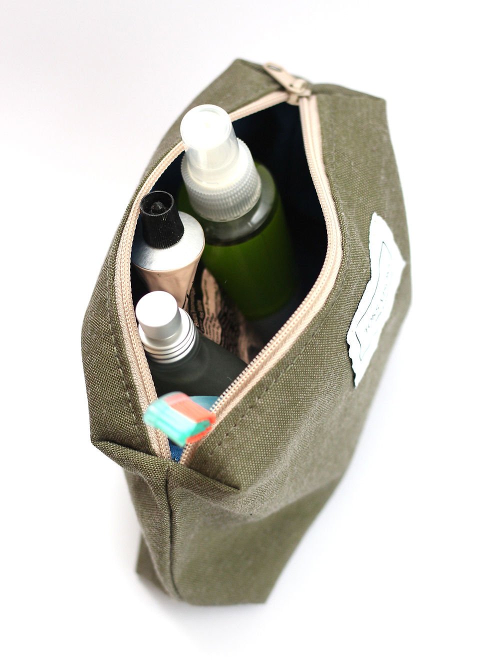 6. Overhead view of TOKS VISOKS LORNA Makeup Bag in army green, showcasing wide zipper and contents