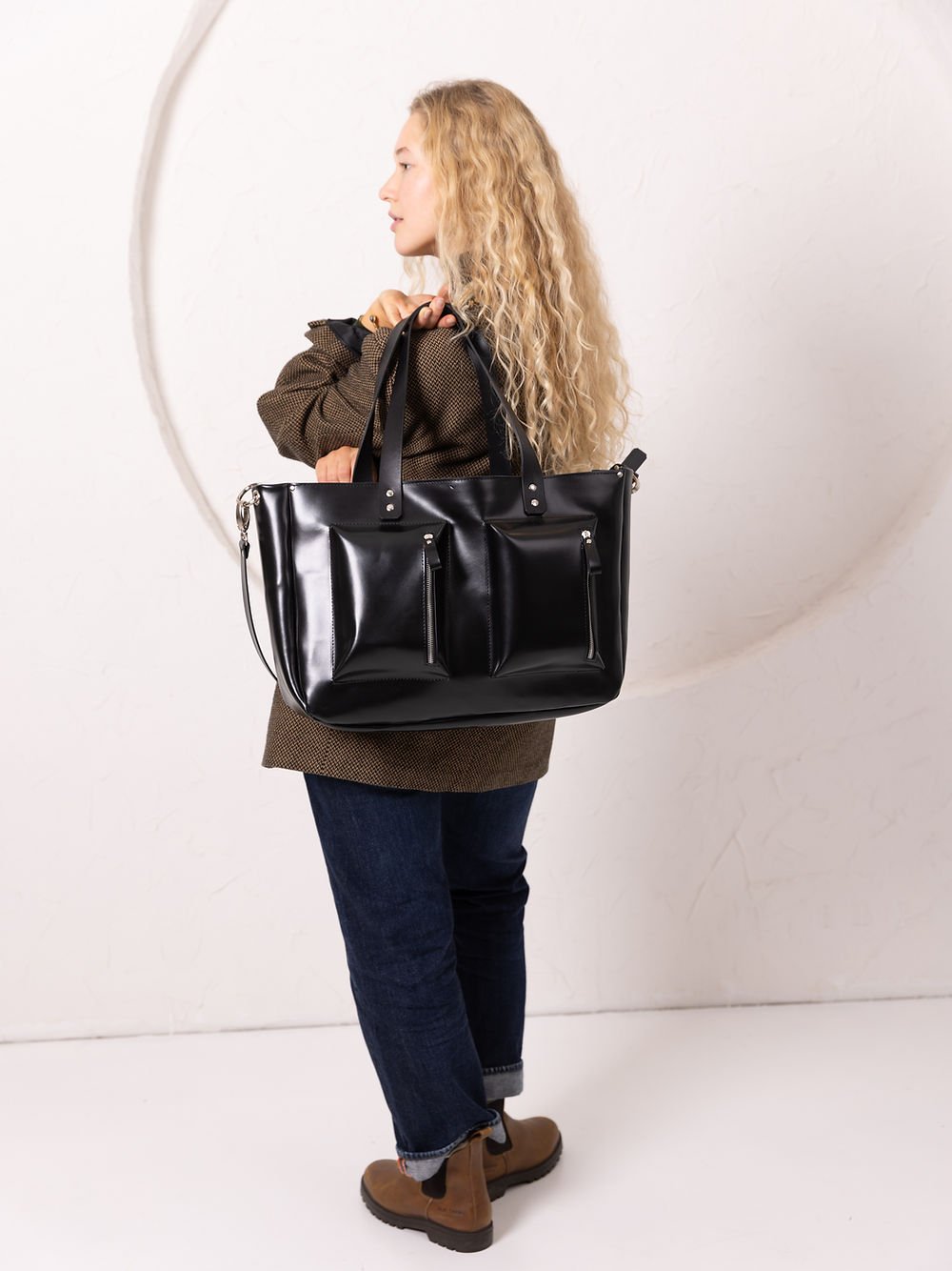 7. Close-up of black AMBER handbag by TOKS VISOKS, highlighting front pockets and zipper details
