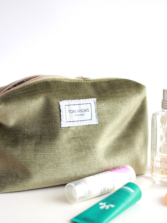 2. Close-up of LORNA Makeup Bag in olive velvet by TOKS VISOKS, featuring brand label and zipper detail