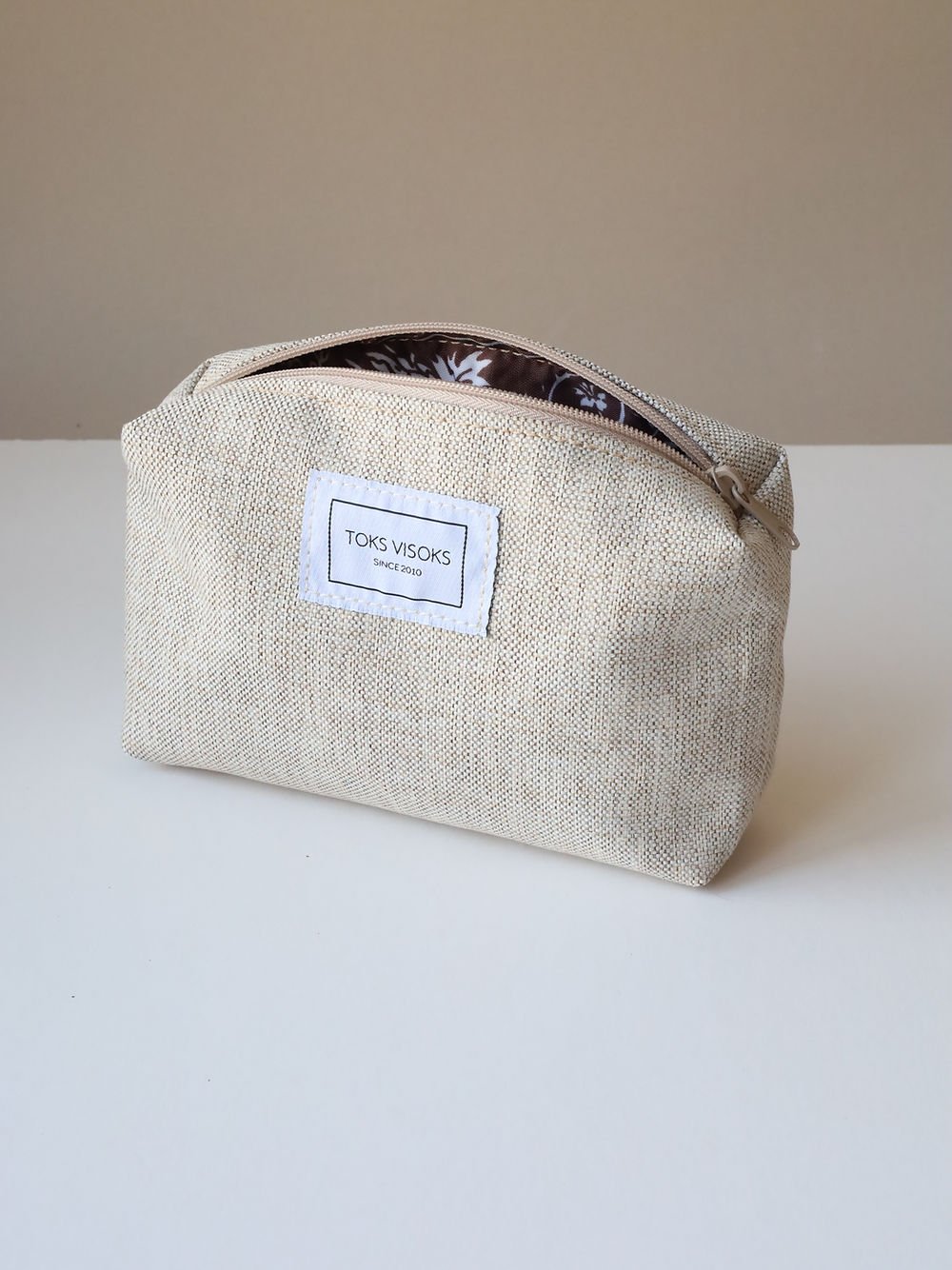 3. Studio shot of TOKS VISOKS LORNA Makeup Bag in White Sand, featuring spacious design and brand label
