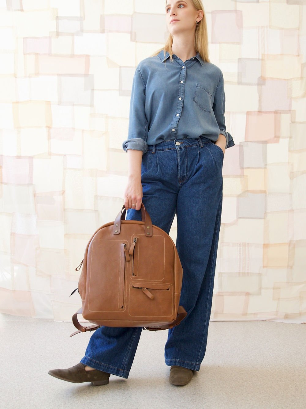 7. Woman standing with TOKS VISOKS GORDON Backpack in Capuccino, lifestyle setting