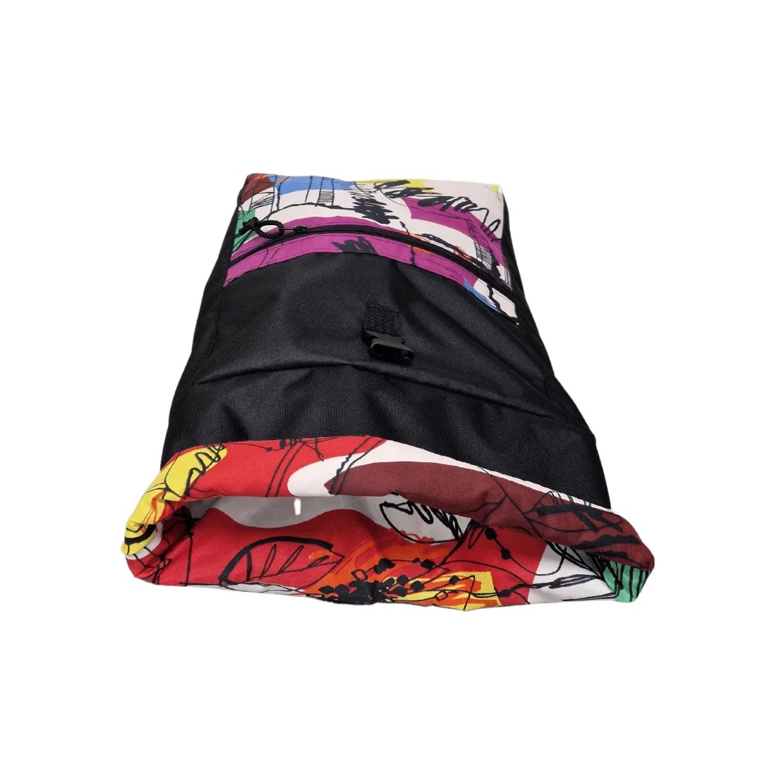 2. Drinbags PAINT waterproof backpack laid flat, showing colorful design and roll-top feature, studio shot