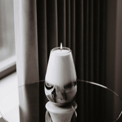 3. Candledust powdered candle burning in an elegant glass container on a reflective surface