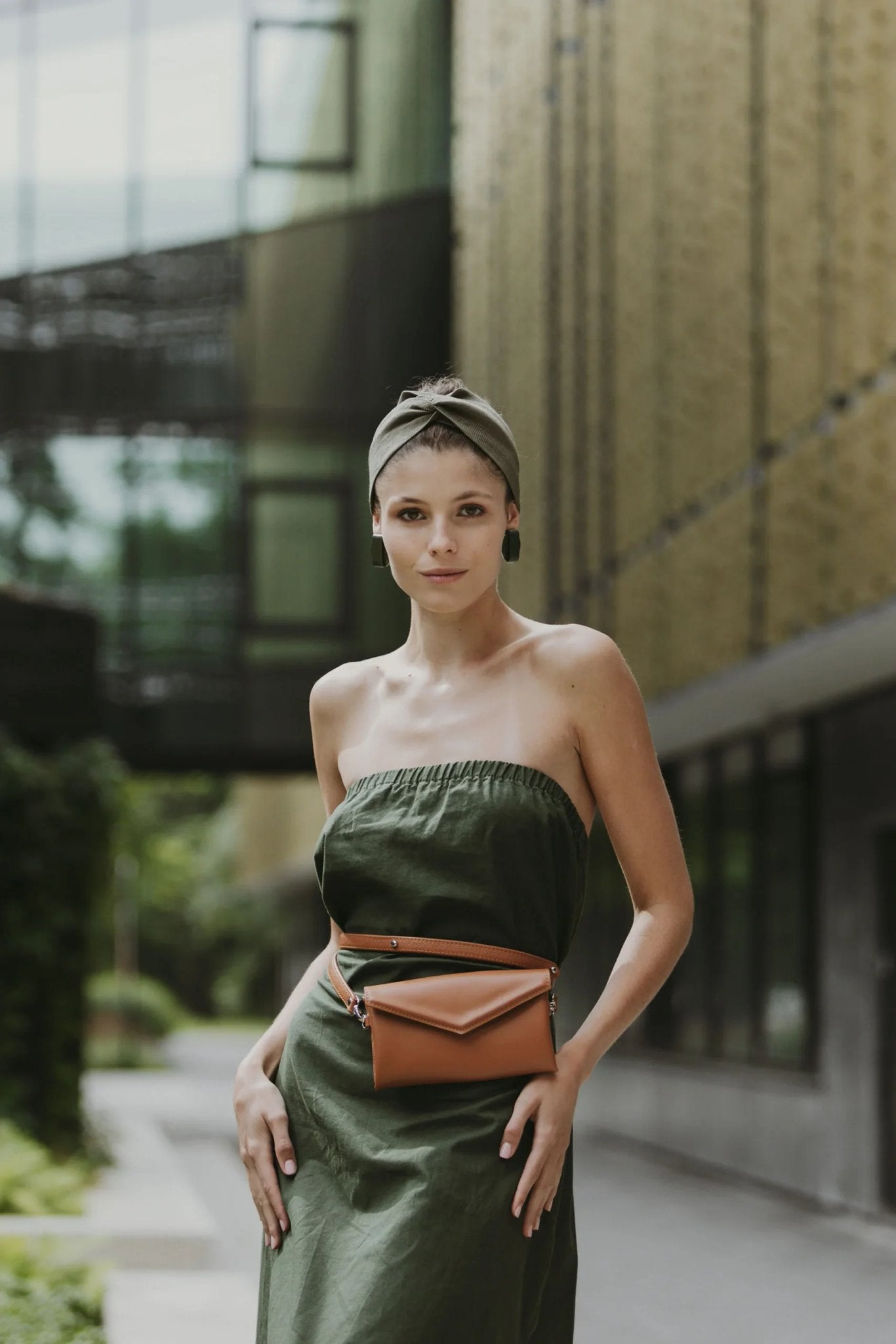 1. Women's brown Gerda Retter waist bag worn with green dress in urban setting