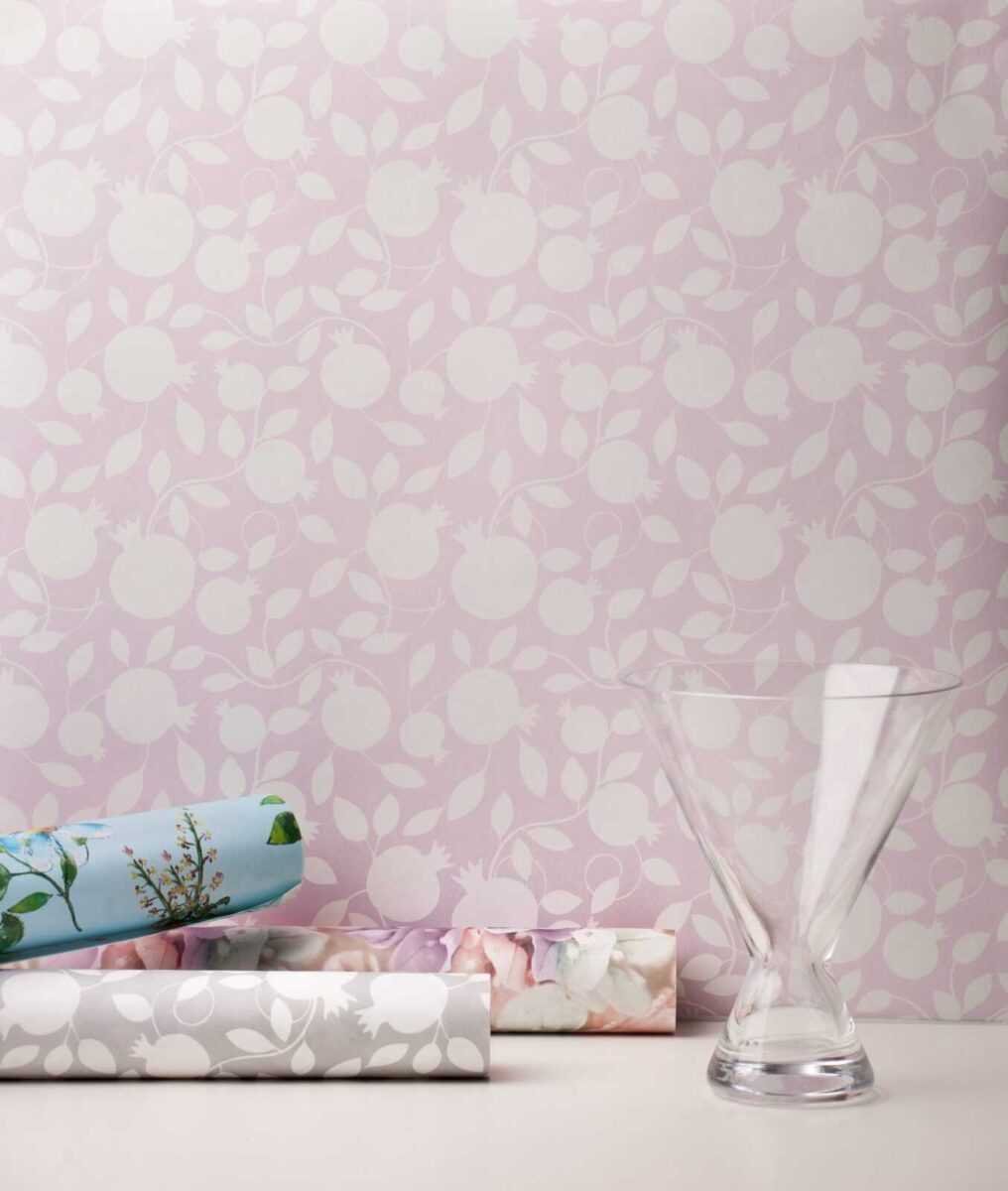 3. Pomegranate pink wallpaper with glass vase and rolled wallpapers in a room setting