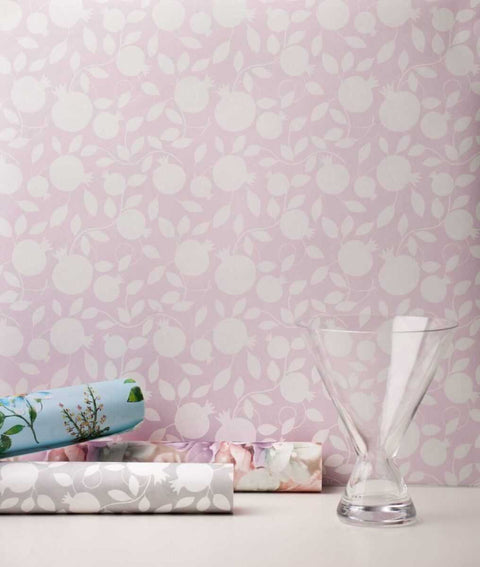 3. Pomegranate pink wallpaper with glass vase and rolled wallpapers in a room setting