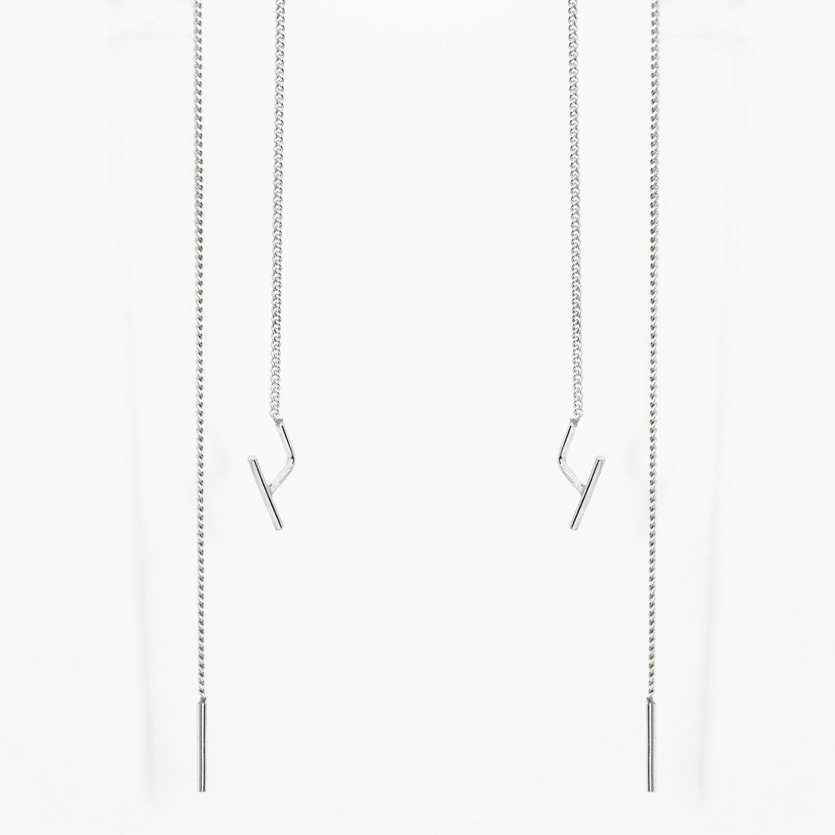 2. Studio image of Maarja Palu SWING earrings with long silver chains and minimalist design