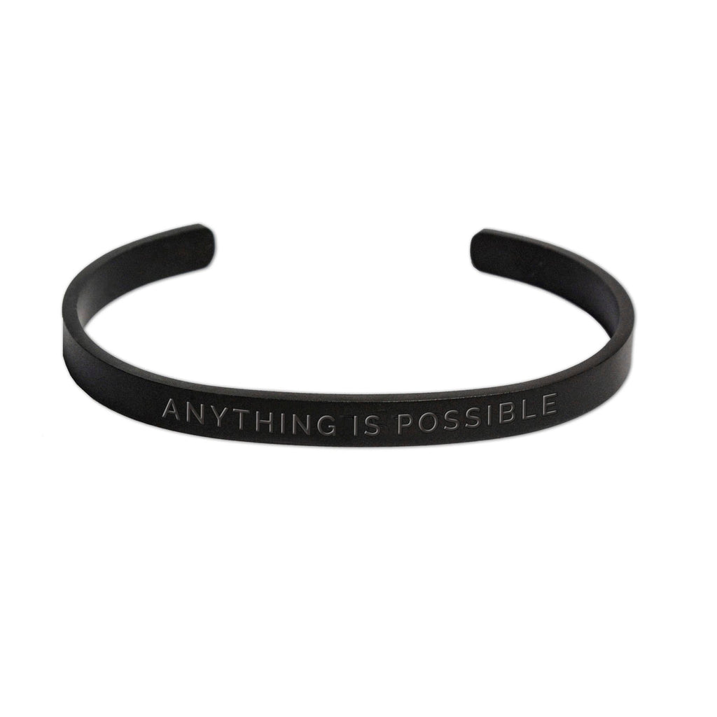 1. Men's matte black Olla bracelet with 'Anything Is Possible' engraving, shown in studio