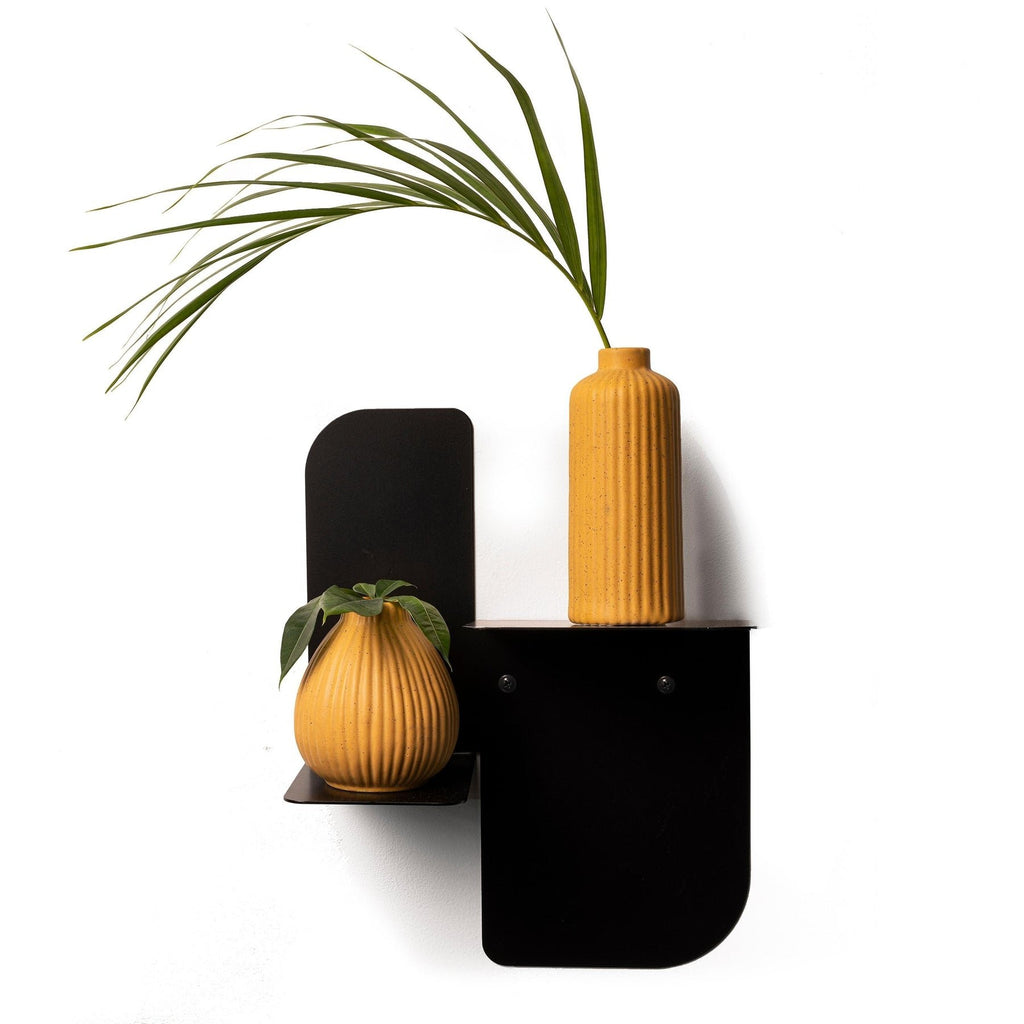 1. Black metal floating wall shelf with two yellow vases and green plant, minimalist style