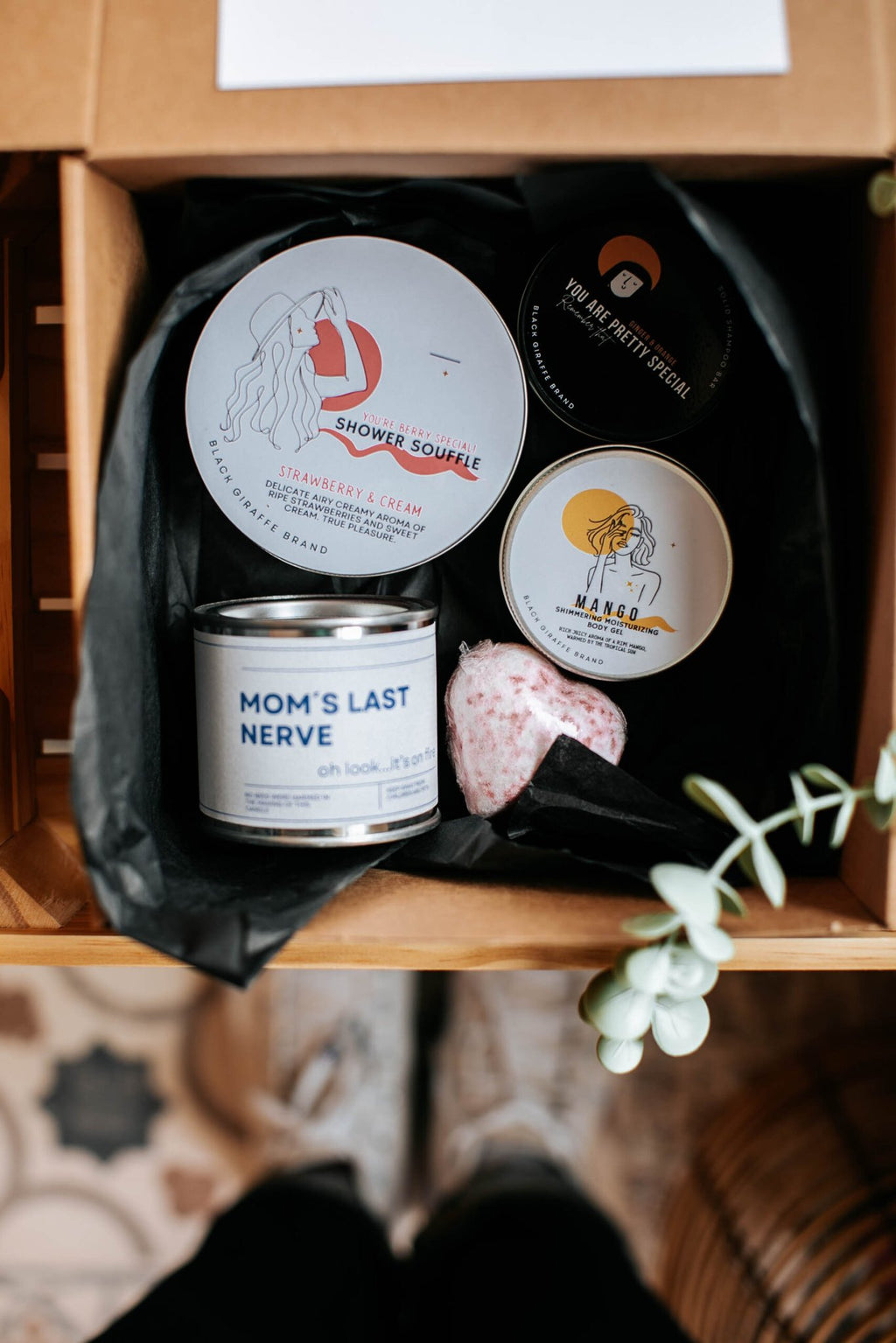 3. Close-up of Black Giraffe Body Care Gift Set contents, including shower cream, shampoo bar, and soy wax candle