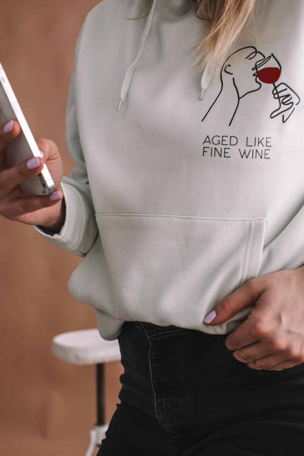 3. Close-up of Black Giraffe Brand 'Aged Like Fine Wine' hoodie in light green, showing design and text