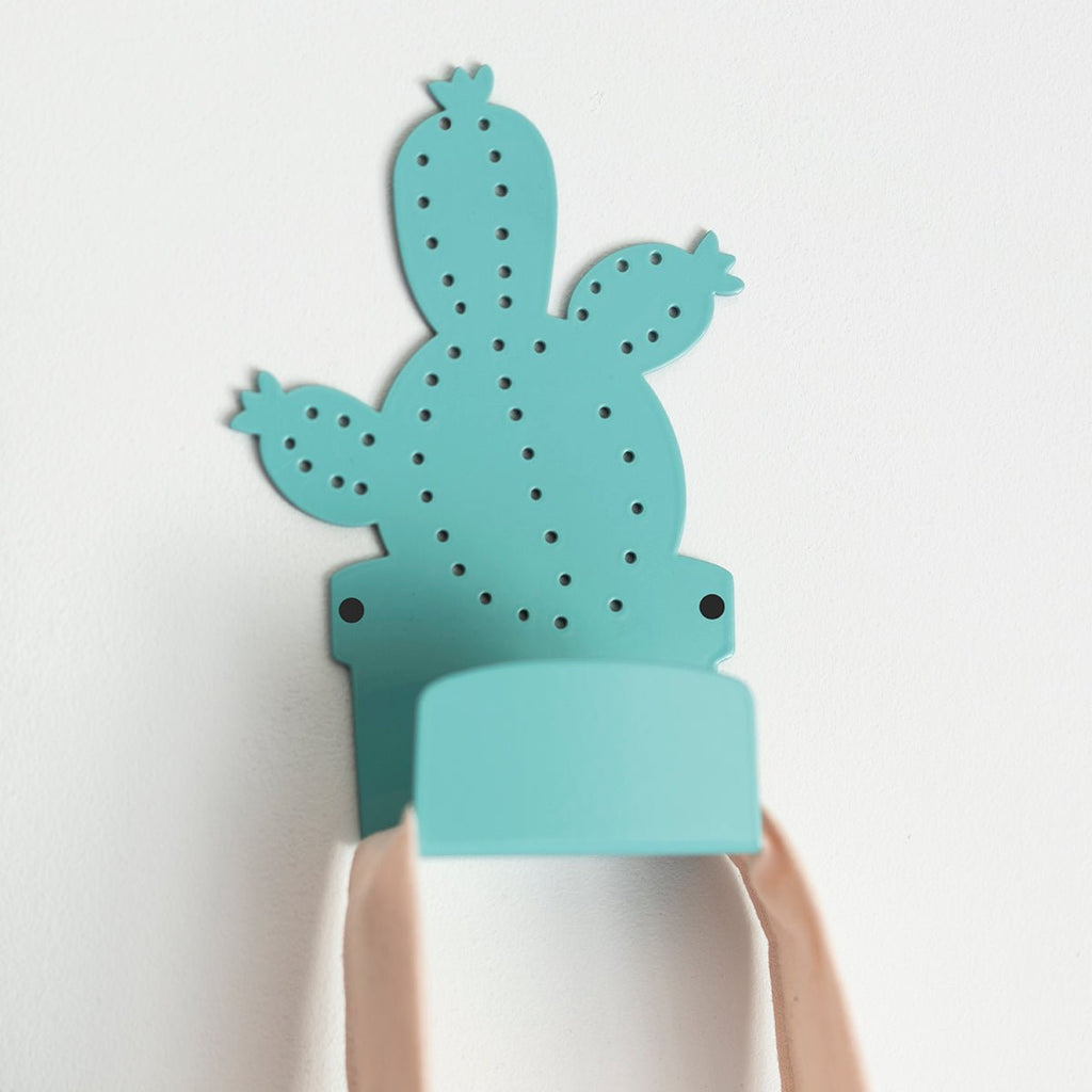 7. Blue cactus-shaped metal hanger mounted on wall, holding a pink bag